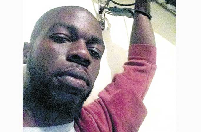 Errol Nisbeth in cuffs after being arrested for taking photo via jamaicaobserver.com