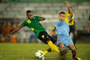 Junior Flemmings tackles St Lucian player - Image via jamaicafootballfederation.com